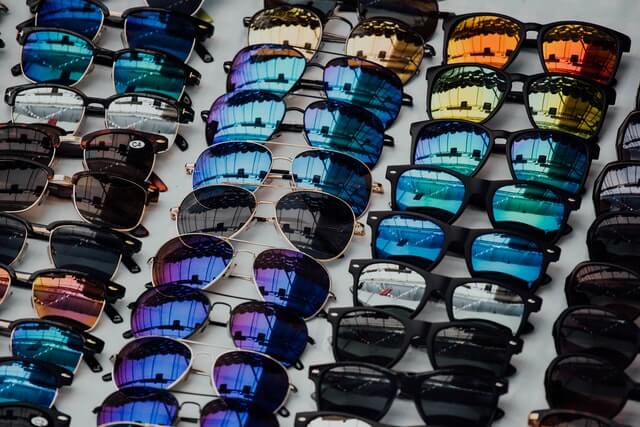 Rows of sunglasses with different glass tints and different frames. 