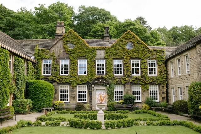 New vinyl windows adorn an old ivy-covered manor. The contrast of the white windows on the green and browns catches one's gaze. 