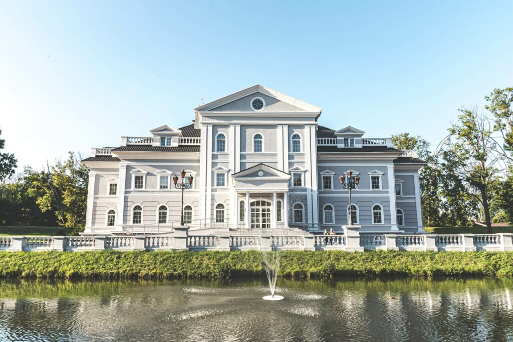 The front view of a beautiful mansion. This is an example where arched windows styles with decorative bars are on display.